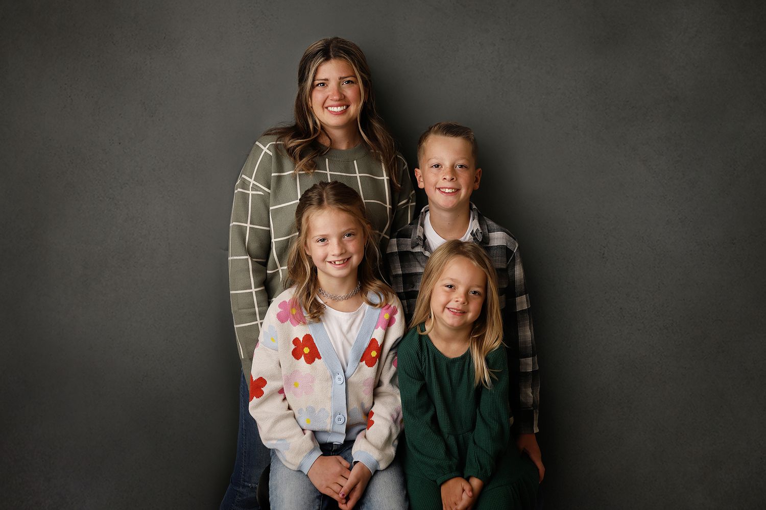 A series of five professional family portraits showing joyful moments against a dark gray backdrop.