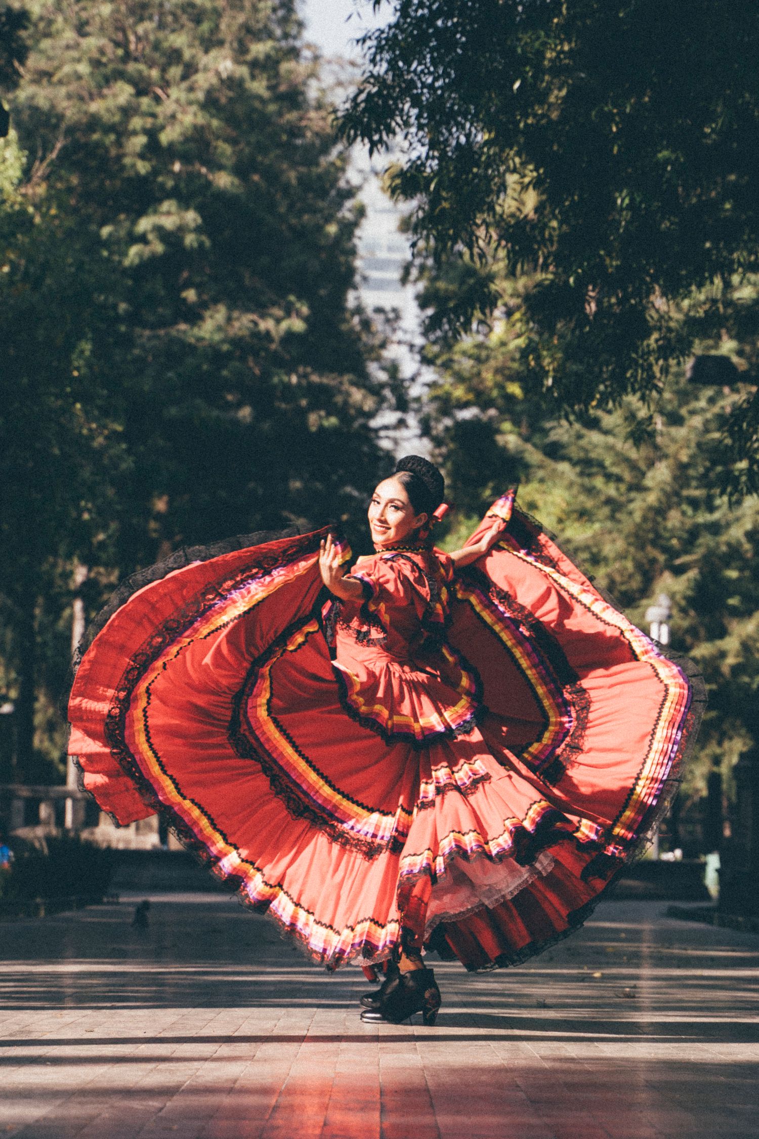 Professional Ballet Folklórico dance photoshoot capturing movement among trees in Alameda Central Park