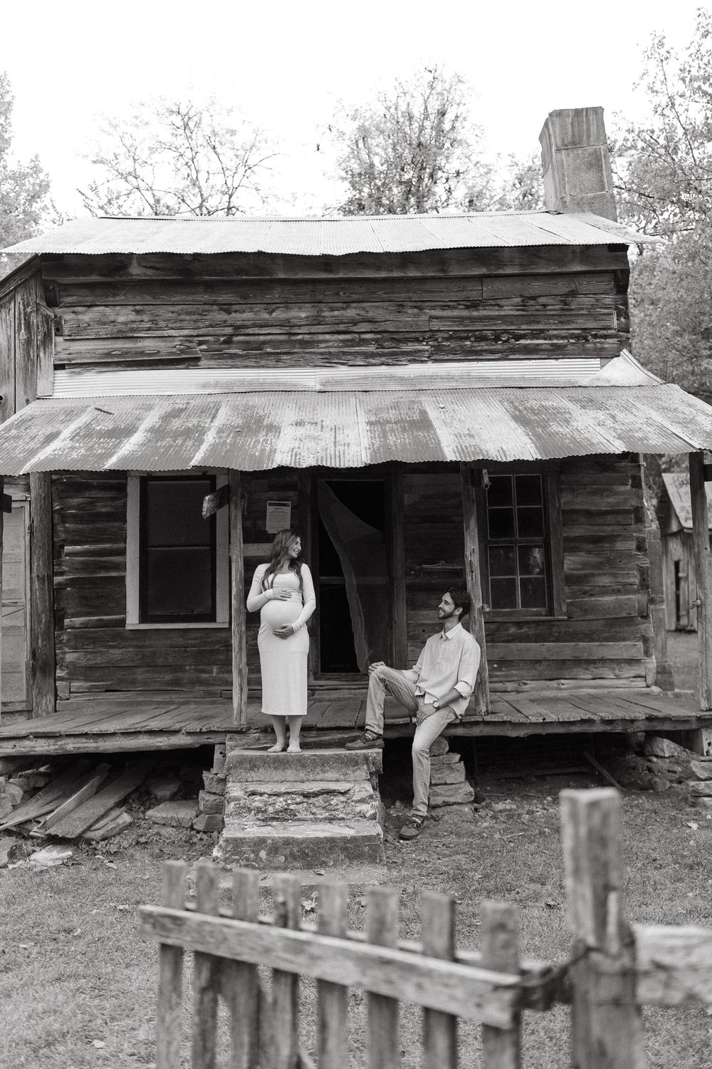 Old wooden cabin with metal roof and porch serves as backdrop for outdoor photography.