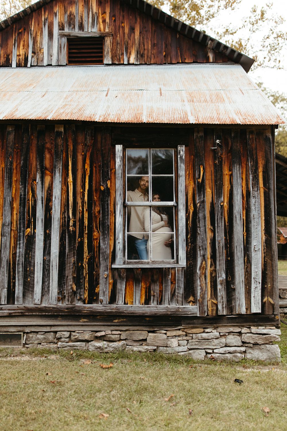 Rustic wooden cabin exterior with weathered vertical boards and stone foundation showing signs of age and character.