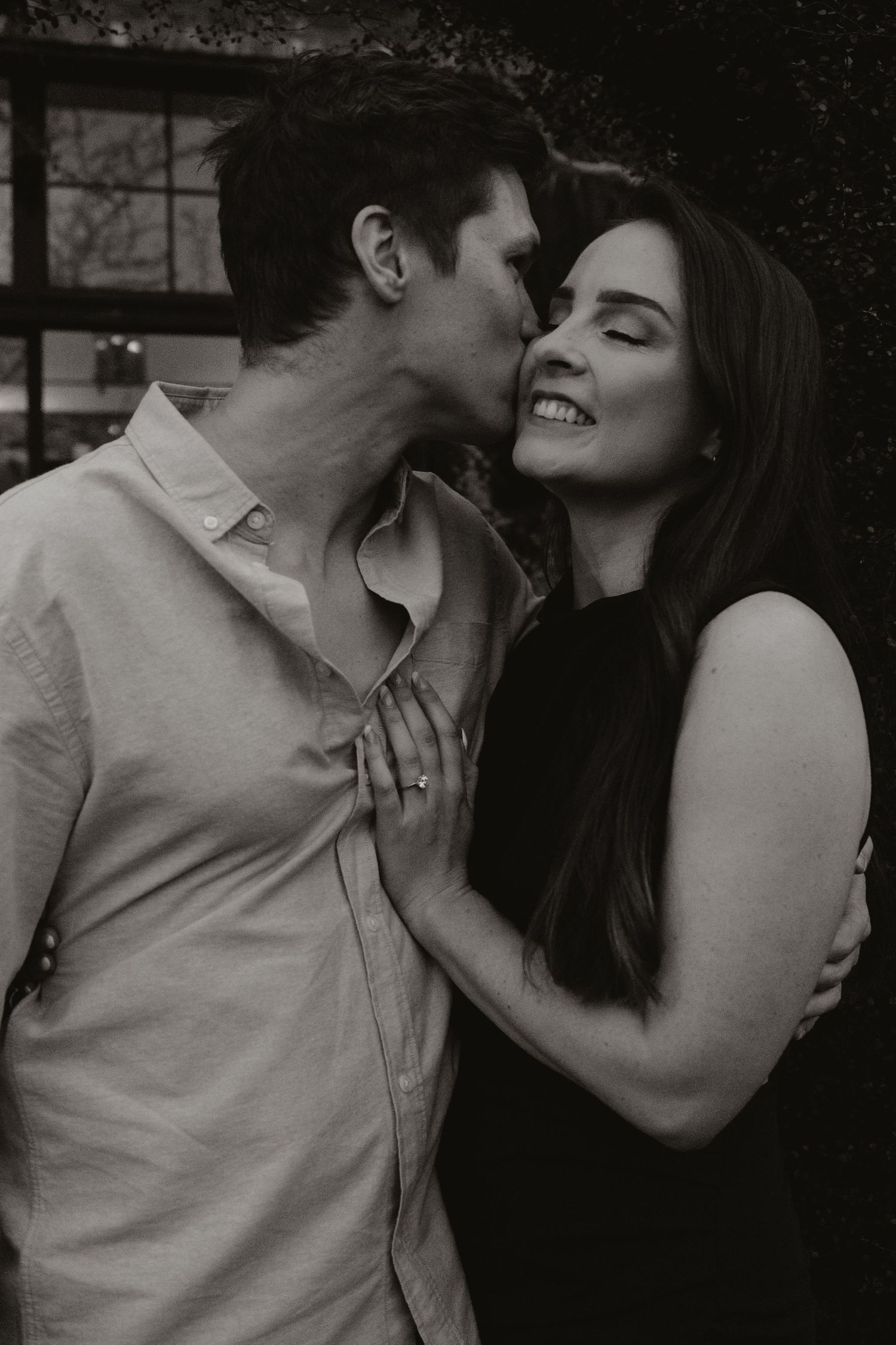 Intimate black and white portrait of a couple sharing a joyful moment indoors.