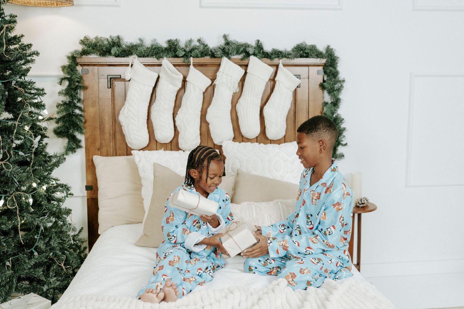Cozy holiday photos with matching light blue pajamas and white bedding.