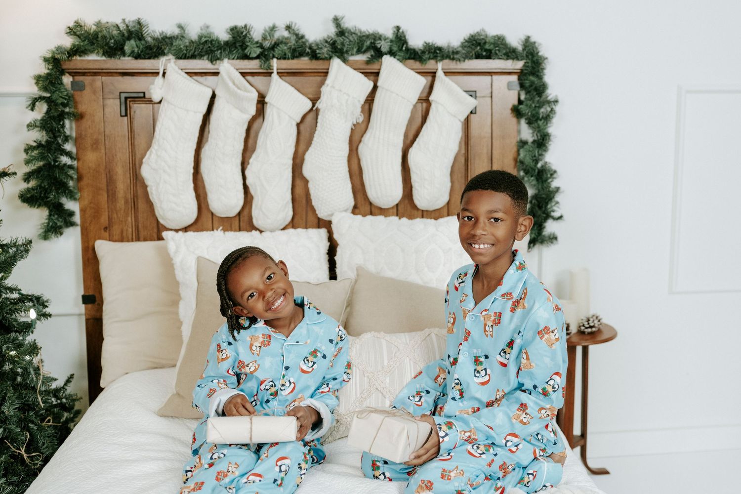 A cozy holiday setting with matching blue pajamas and a Christmas tree in the background.