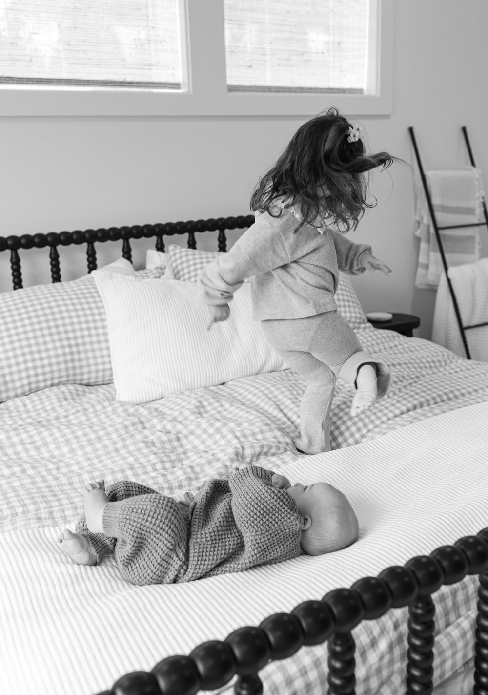 A sequence of black and white photos showing a baby lying on a gingham patterned bed with decorative headboard.
