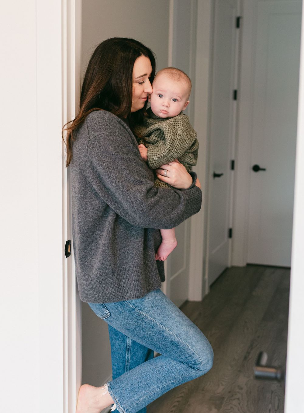 A series of tender moments between parent and child in a minimalist hallway setting.