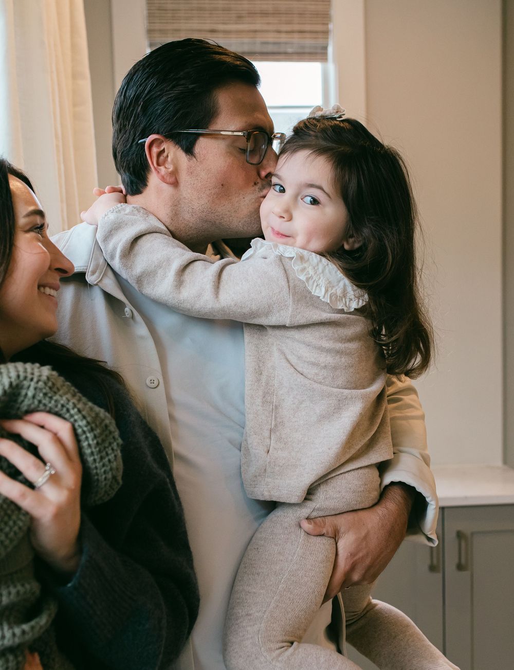 Four sequential photos showing a couple embracing and sharing intimate moments in a sunlit room.