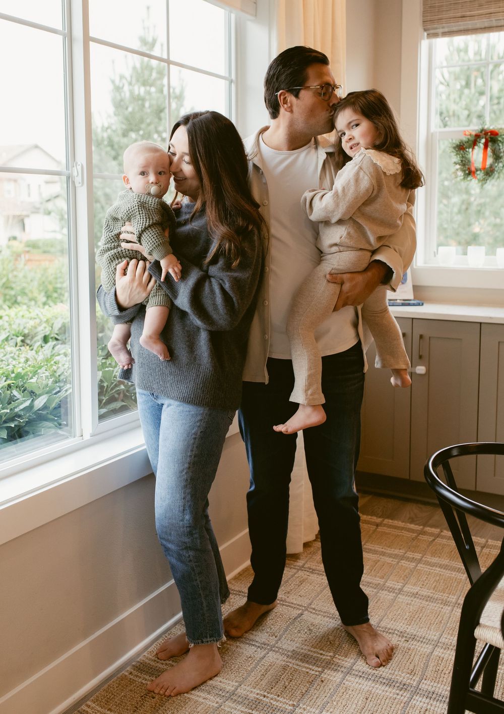 Family spending quality time together in a bright sunlit room with bamboo shades and hardwood floors.