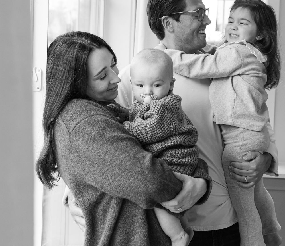 A series of tender black and white photos showing a parent in a gray sweater holding and bonding with a small baby.