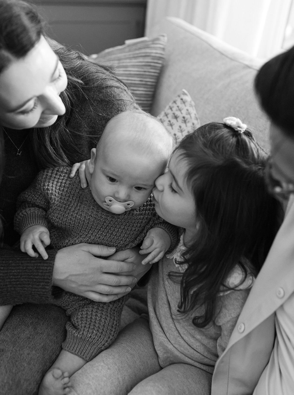 A series of black and white photographs showing tender moments of affection between parent and child.