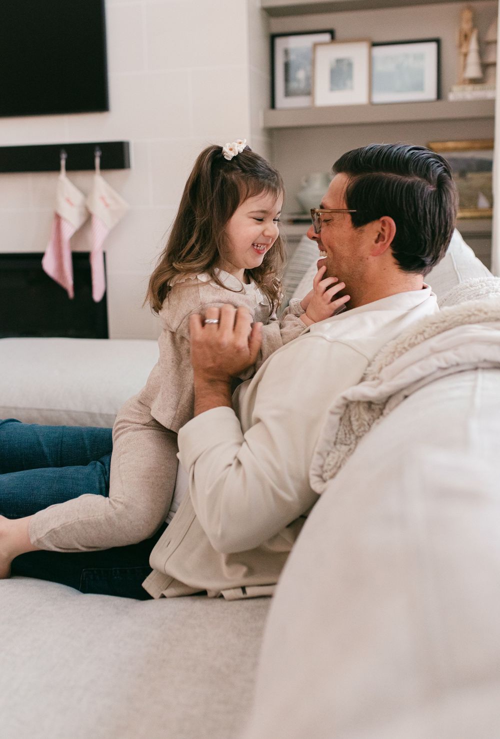 A series of intimate moments showing a couple in white clothing embracing on a couch.