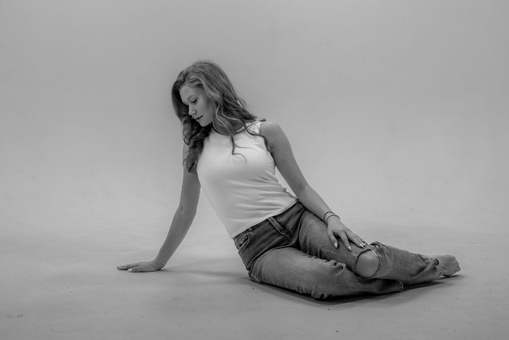 A series of black and white photos showing graceful dance movements and poses on the floor.