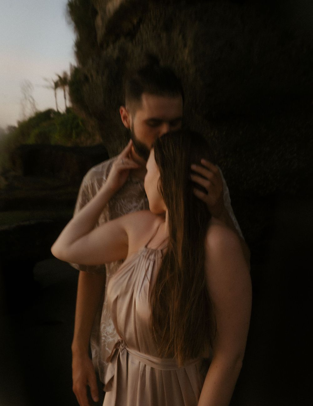 A romantic beach photoshoot captured in soft, moody lighting.