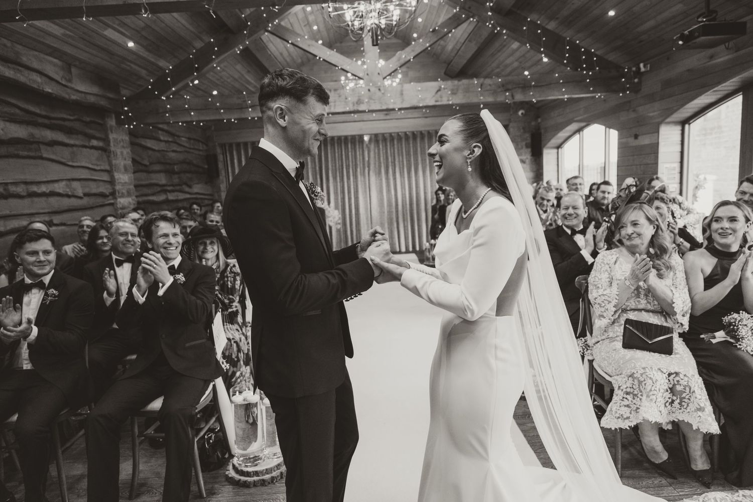 A series of black and white wedding photos showing couples dancing and celebrating at an elegant reception venue.