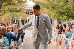 Guests celebrate during an outdoor autumn wedding reception with colorful fall trees in the background.