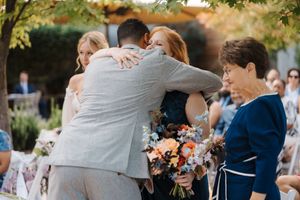 Wedding guests dancing and celebrating at an outdoor reception during golden hour.