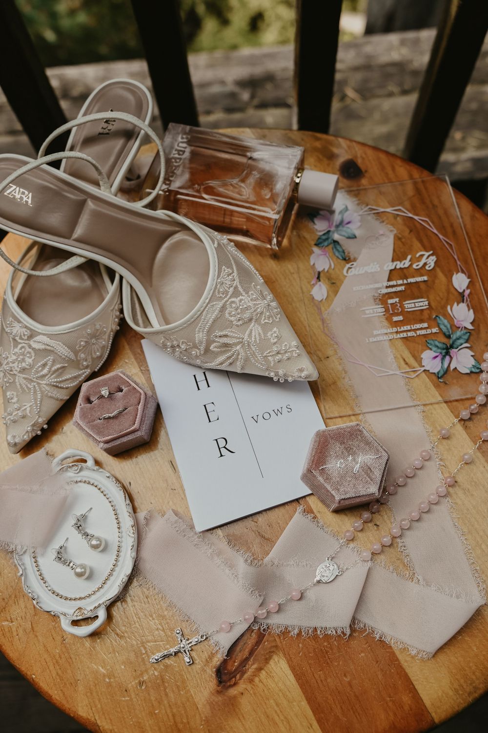Wedding detail shots of delicate handmade paper decorations and accessories laid out on a wooden surface.