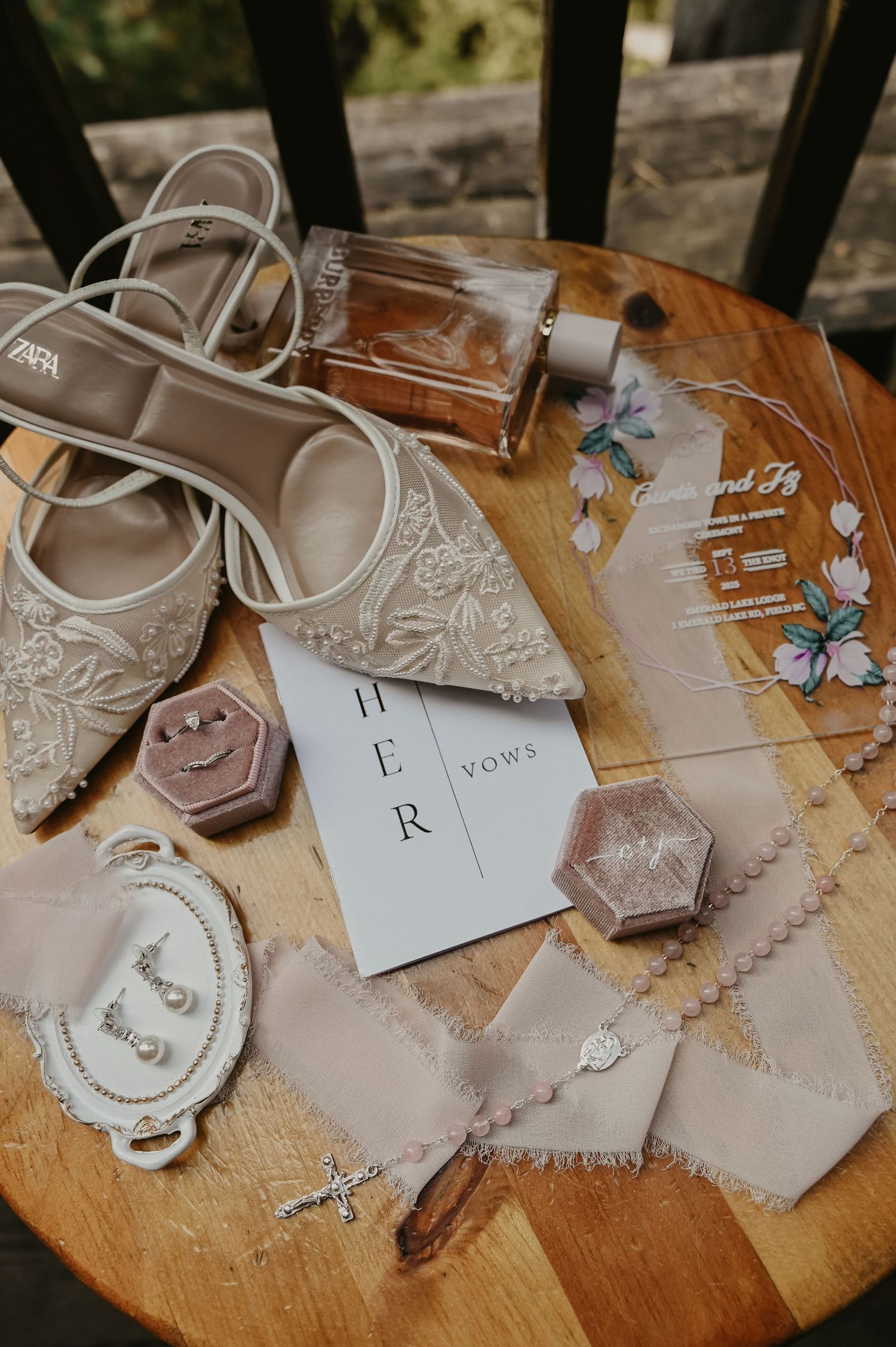 Wedding detail shots of delicate handmade paper decorations and accessories laid out on a wooden surface.