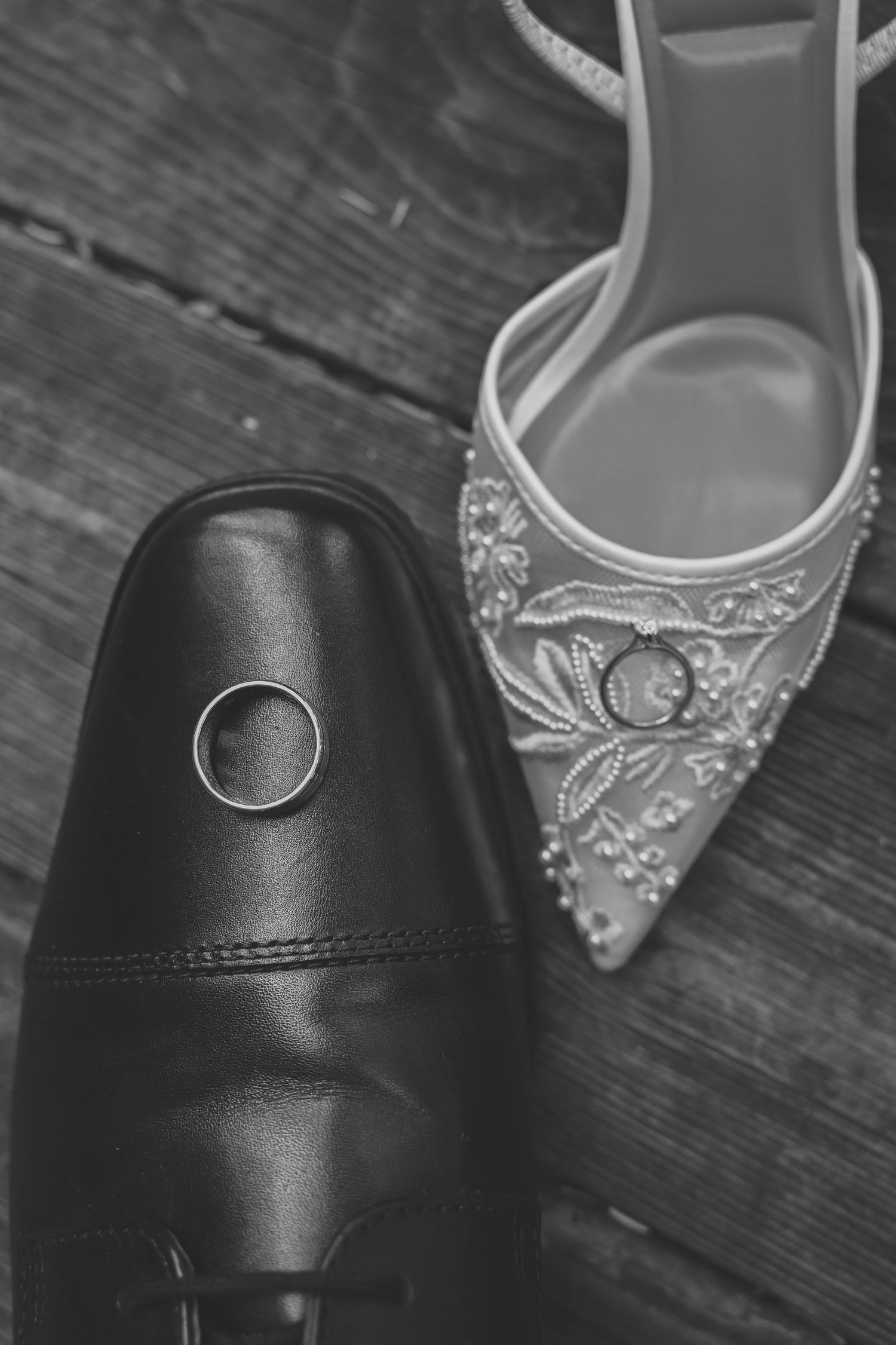 Close-up view of elegant bridal shoes in black and white showing intricate beaded details and classic designs.