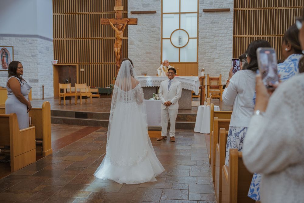 Wedding ceremony in progress inside modern church with wooden accents and white walls.