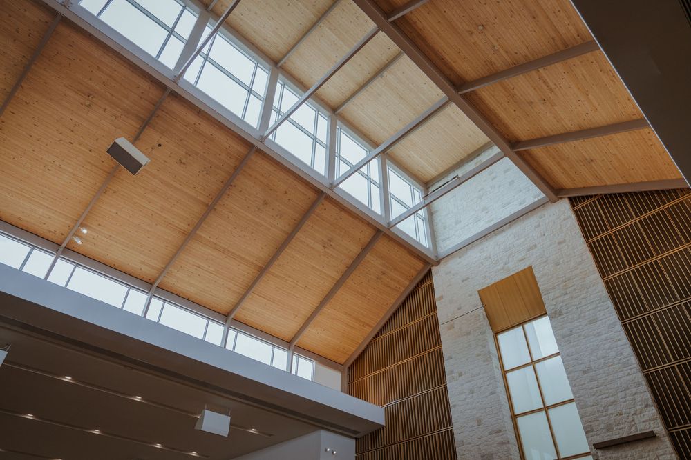 Modern church architecture featuring wooden beams and natural light from skylights.