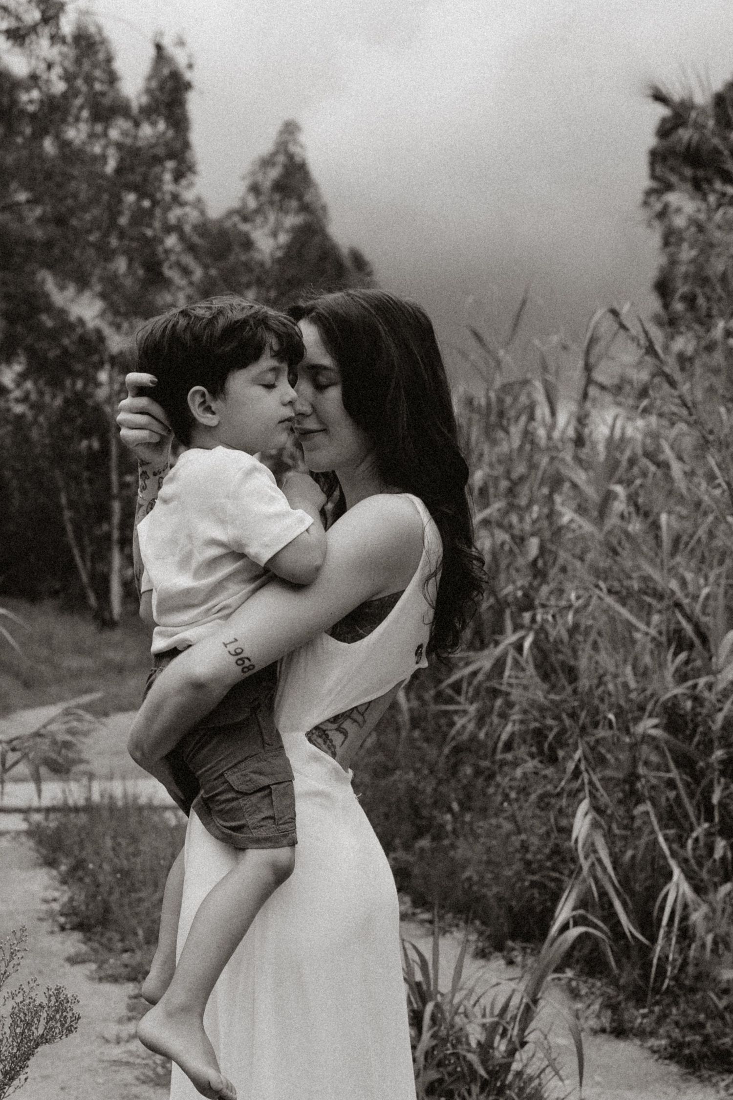 Black and white series of loving family moments on nature path.
