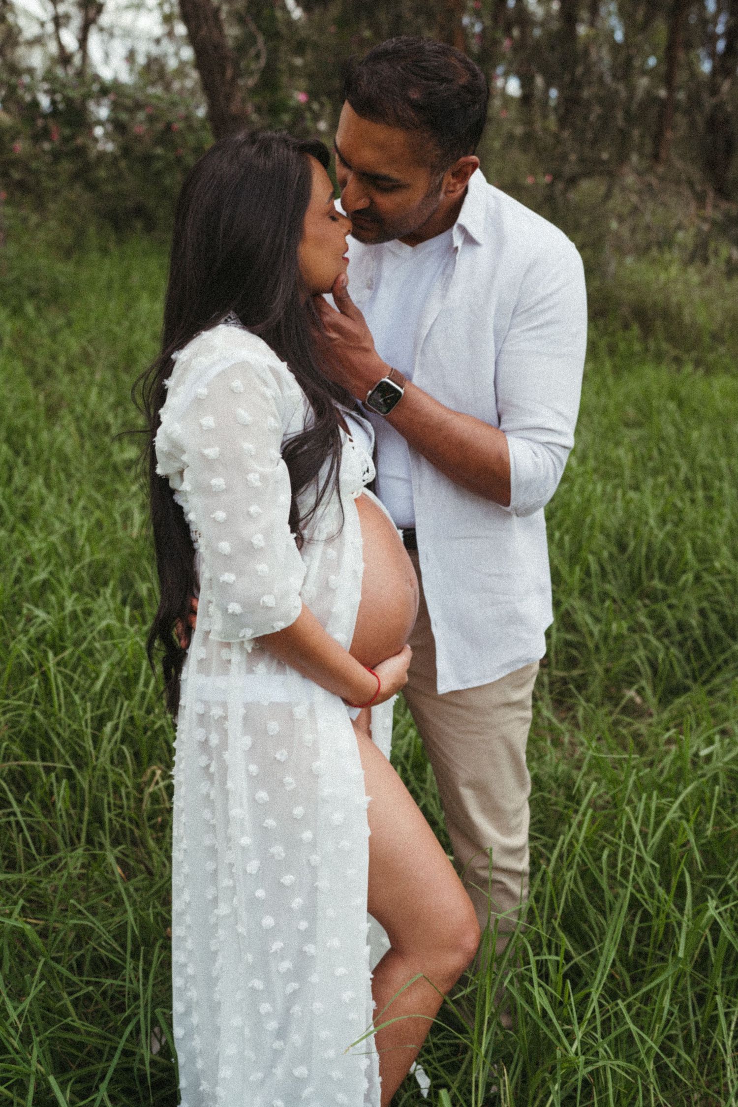 Romantic maternity photos capturing tender moments between couple in nature.
