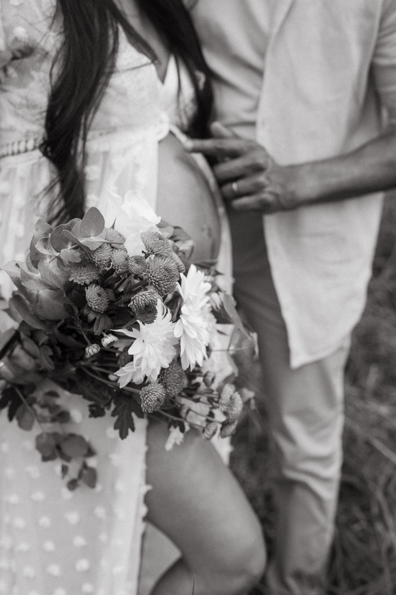 Black and white maternity photo featuring white daisies and lace details.