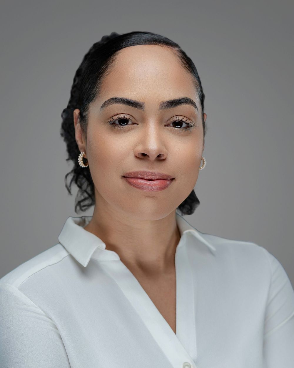 Professional headshot of person in white button-down shirt against grey background. Kelly Photography Atlanta