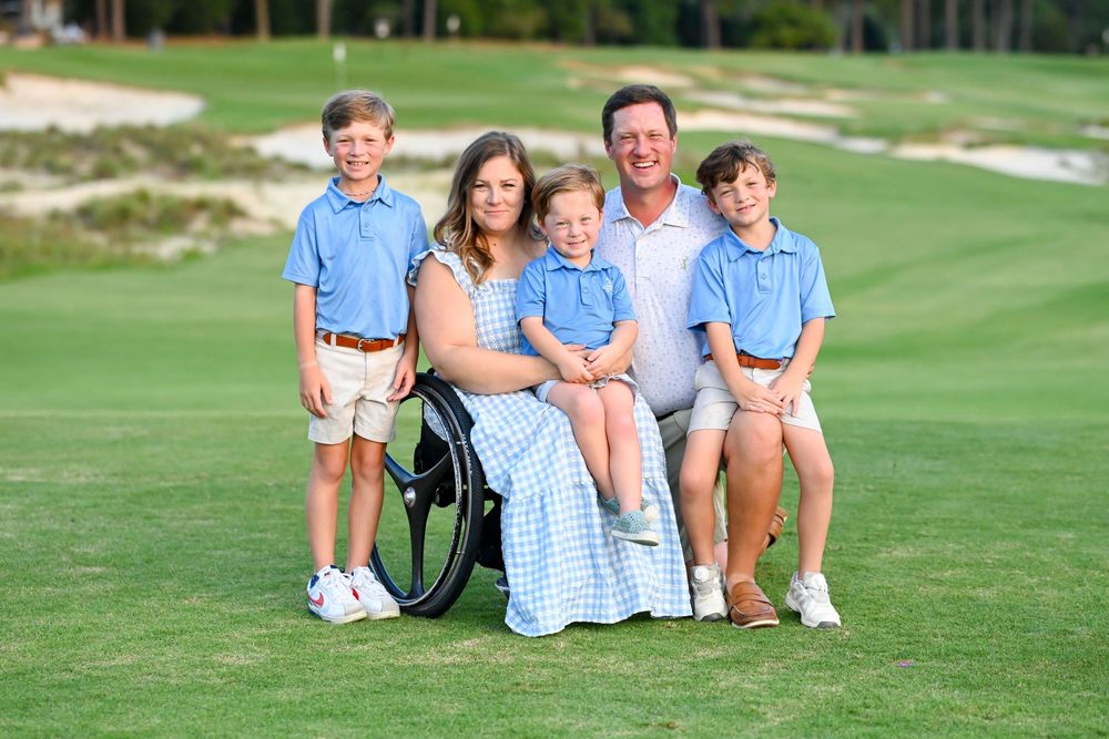Family portrait on golf course with coordinated blue and white outfits.