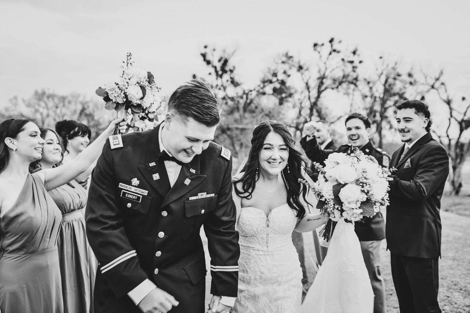 Playful shot of the wedding party striking silly poses and laughing together.