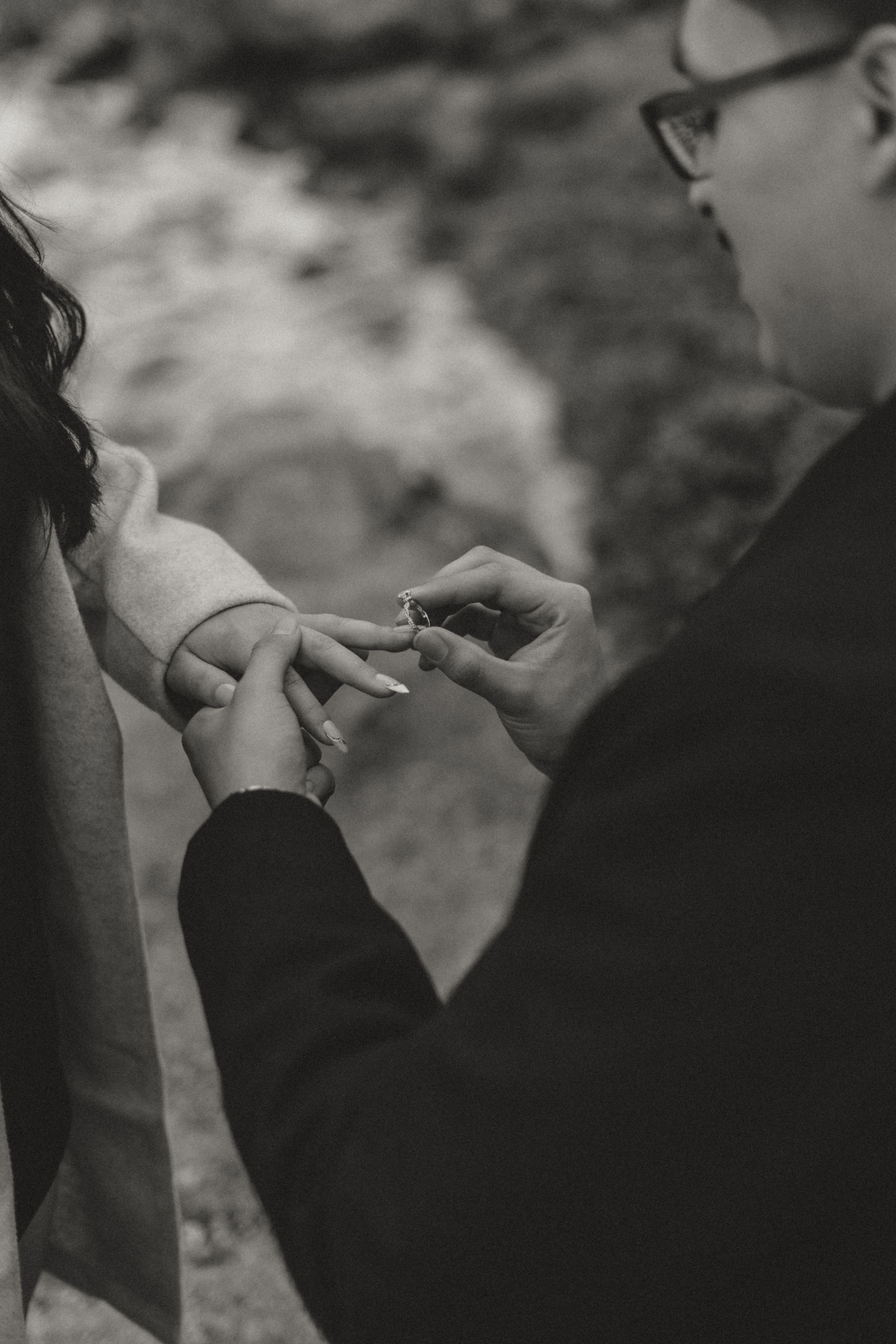 A black and white photo series showing a couple embracing and kissing in a romantic outdoor setting.