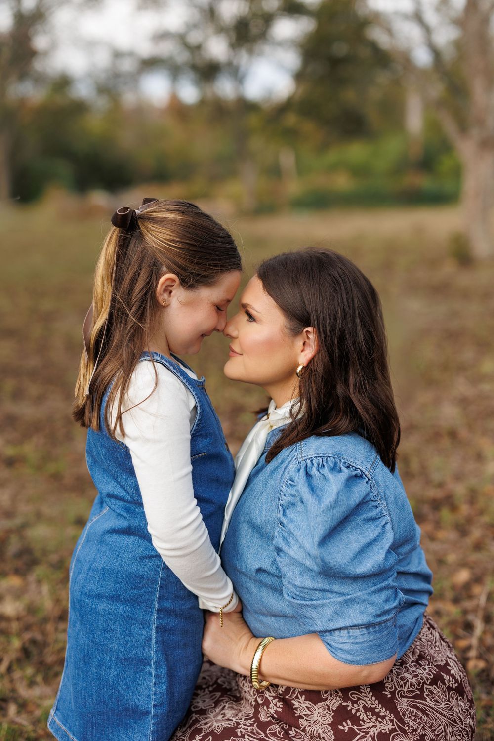 Two people share tender moment outdoors in autumn setting.