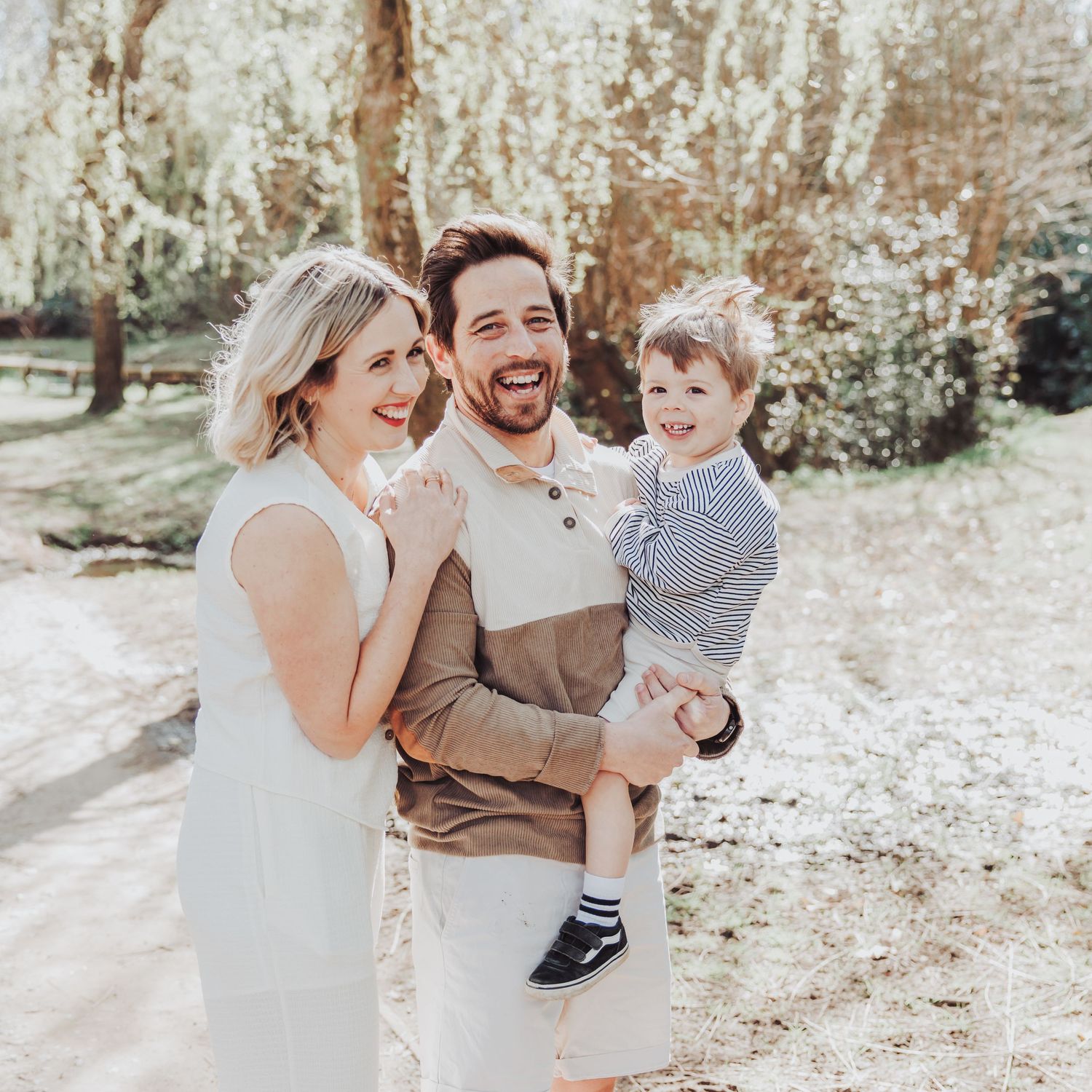 Lovely natural photo of a couple laughing with their little boy.