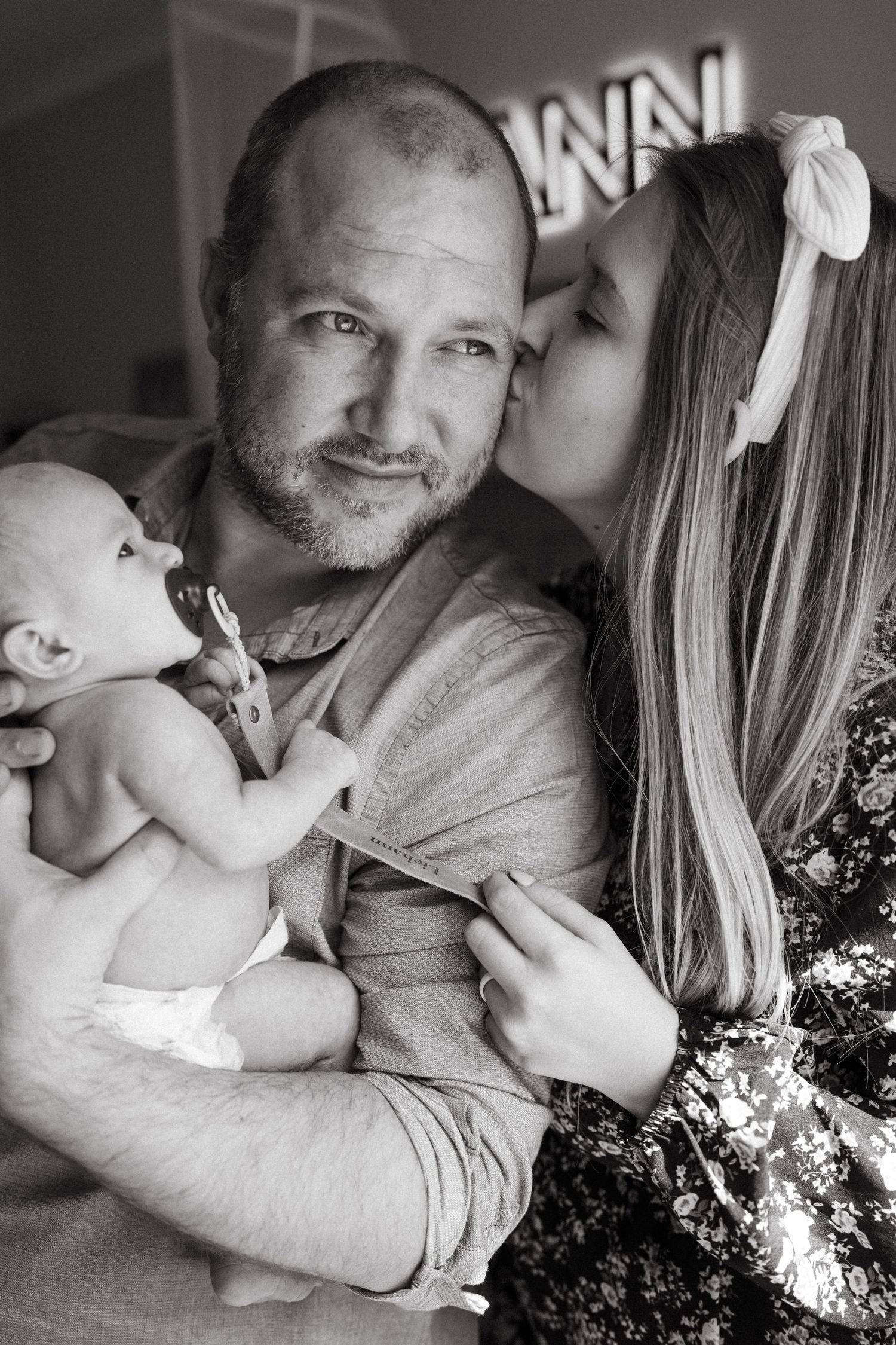 A tender black and white family portrait series showing intimate moments.