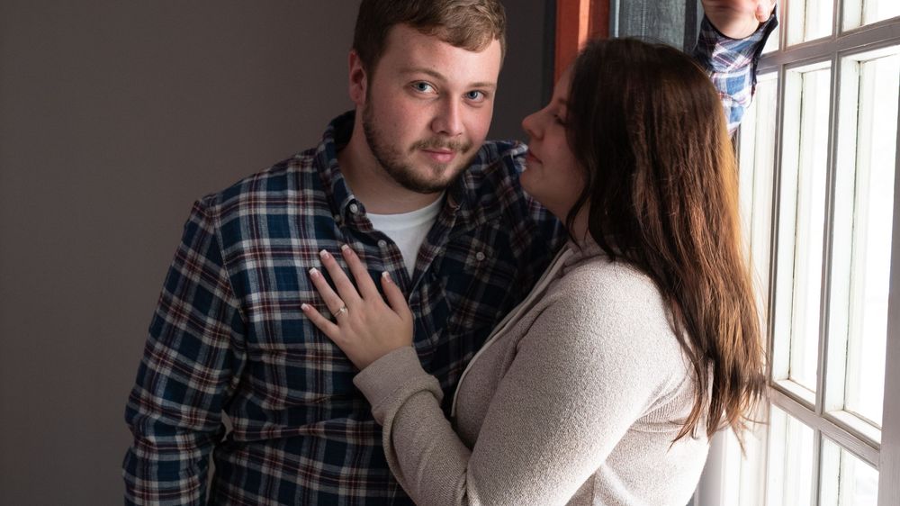 A couple embraces near a window in a romantic sequence of progressive photos showing them getting closer together.