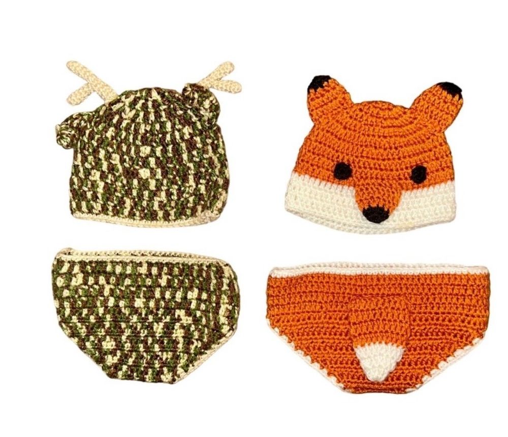 A collection of handmade crochet fox and camouflage baby diaper covers arranged in a row.
