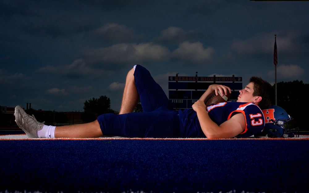 High school football player Media Day relaxed pose on field at night, by Deanna Fox, SportsFox Photography, Hershey PA