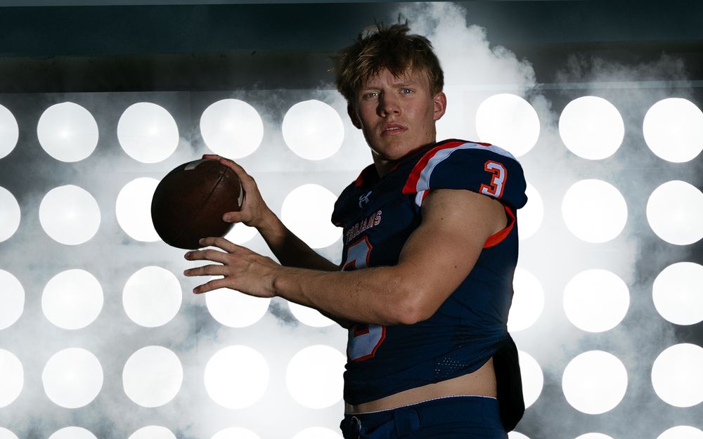 High school quarterback Media Day portrait with stadium lights background, by Deanna Fox, SportsFox Photography, Hershey PA