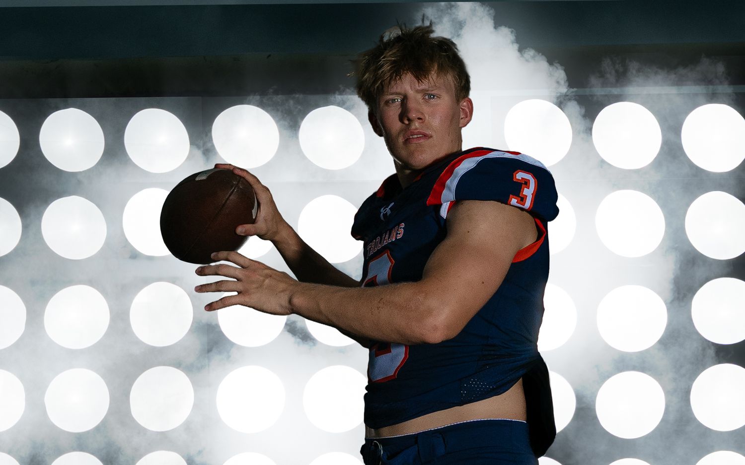 High school quarterback Media Day portrait with stadium lights background, by Deanna Fox, SportsFox Photography, Hershey PA