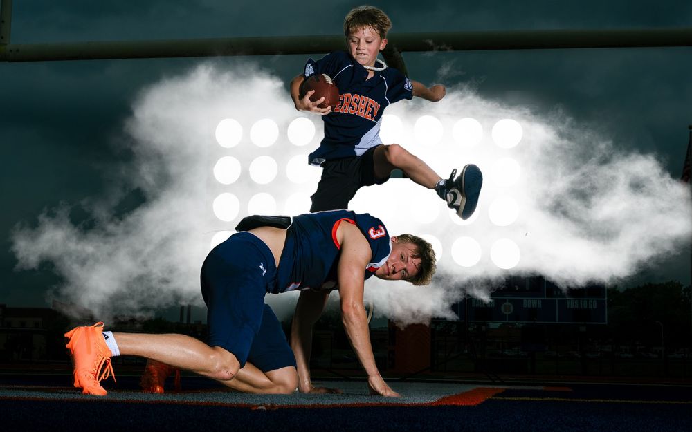High school football siblings Media Day action pose with white smoke effects, by Deanna Fox, SportsFox Photography, Hershey PA