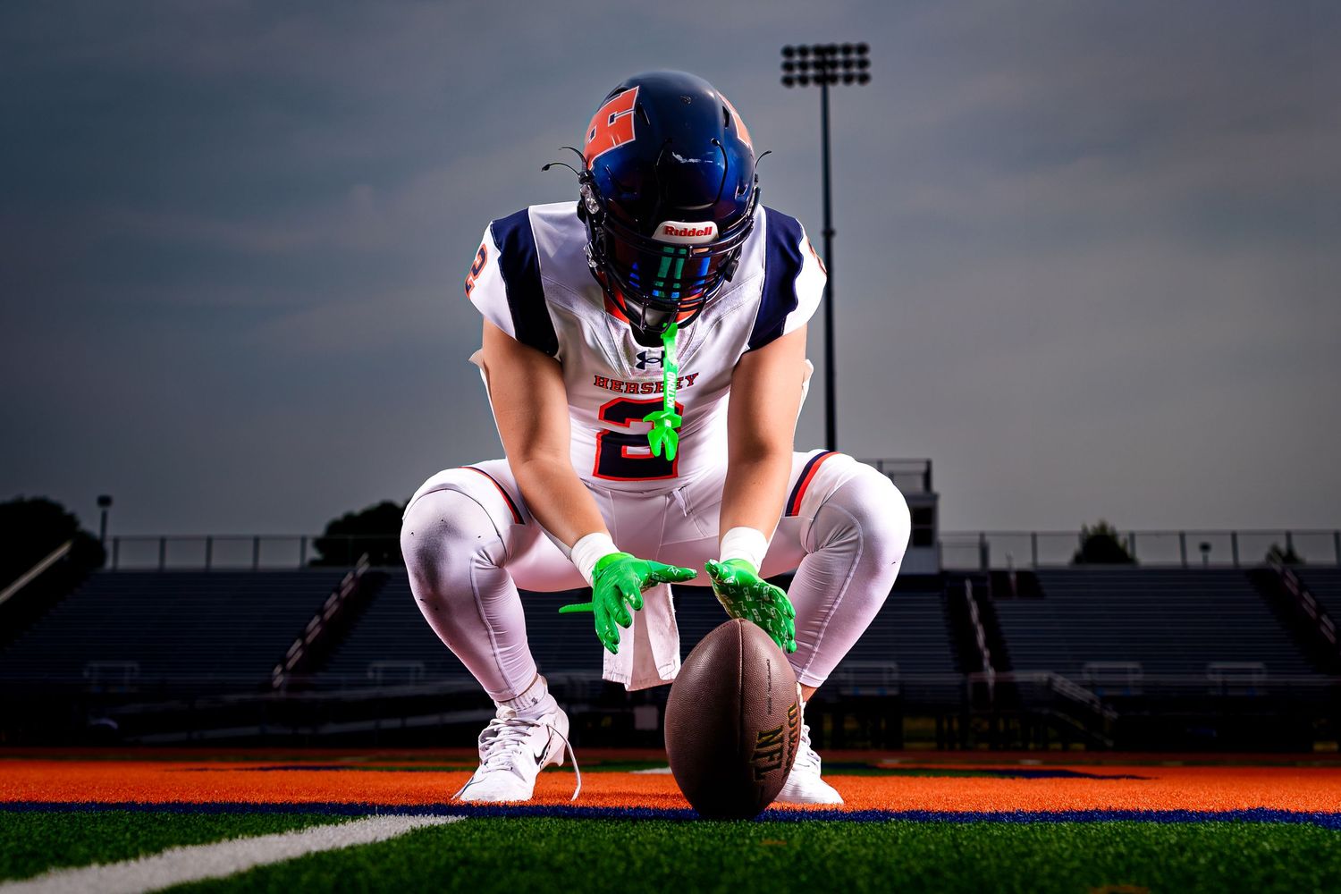 Hershey Trojans football player, crouched holding the football, Media Day portrait, by Deanna Fox, SportsFox Photography based in Hershey PA