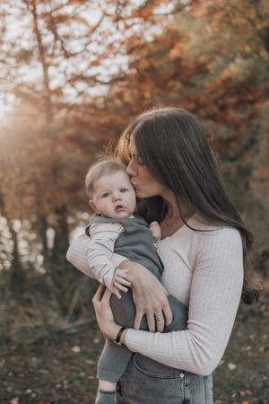 A series of warm-toned photos showing tender moments between parent and baby in an autumn outdoor setting.