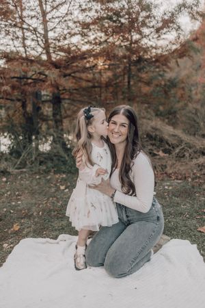 Sweet family interactions on a white blanket outdoors during a fall photoshoot.