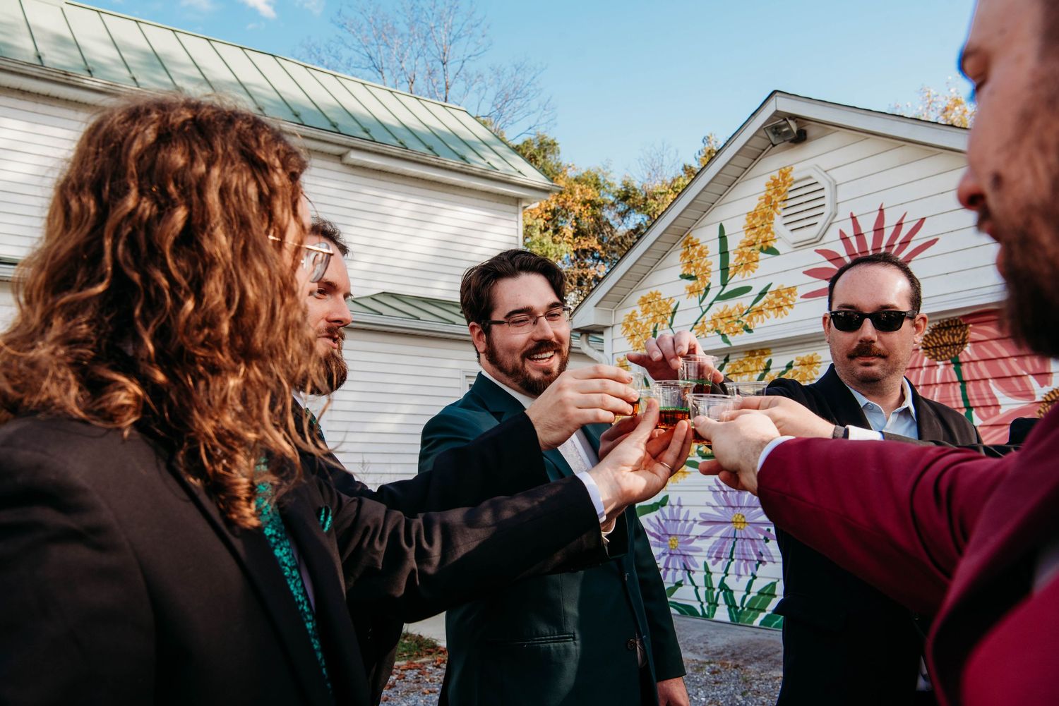 Wedding guests celebrate and dance during an outdoor autumn reception with festive decorations.