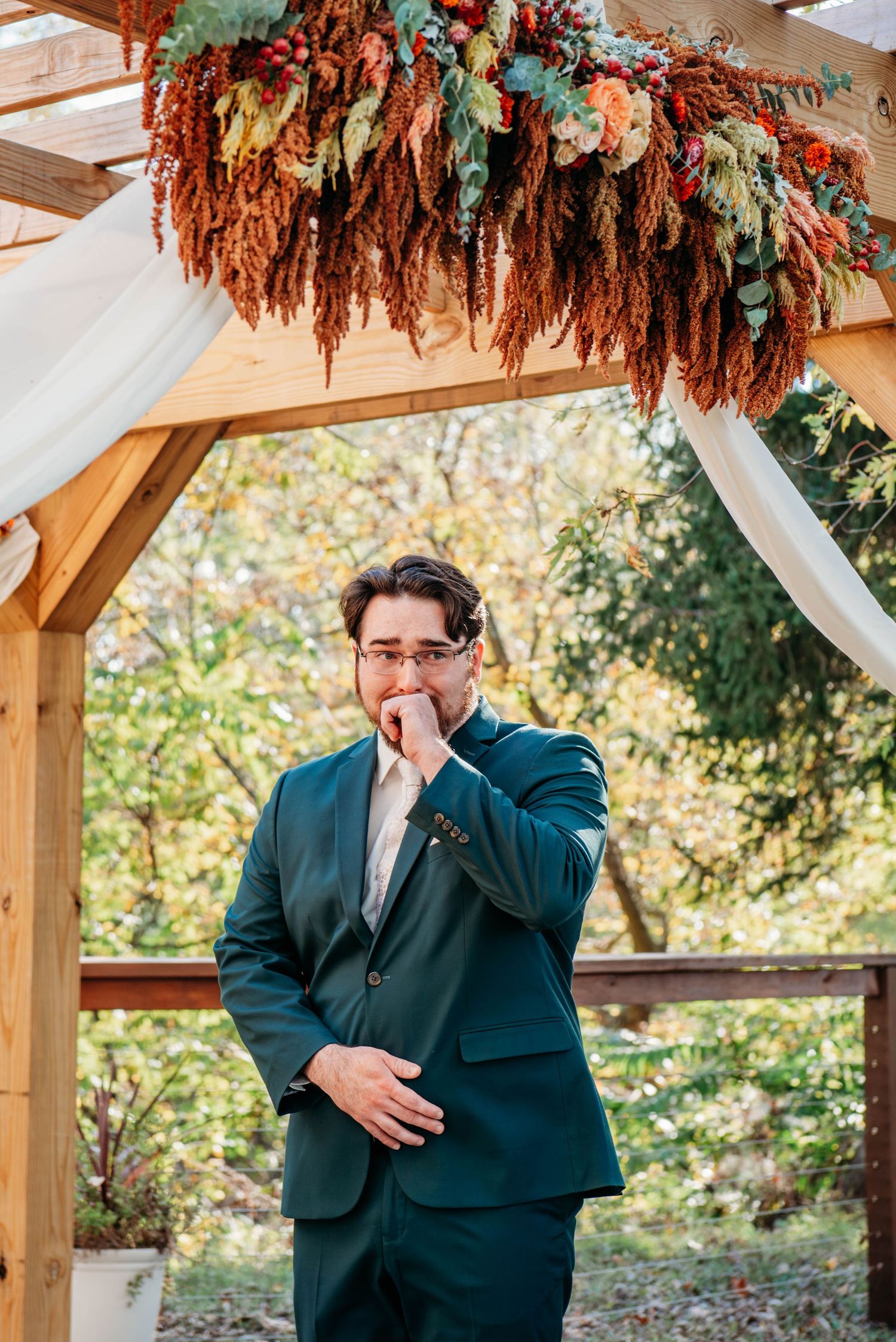Emotional reactions captured during a wedding ceremony under a wooden pergola decorated with autumn florals.