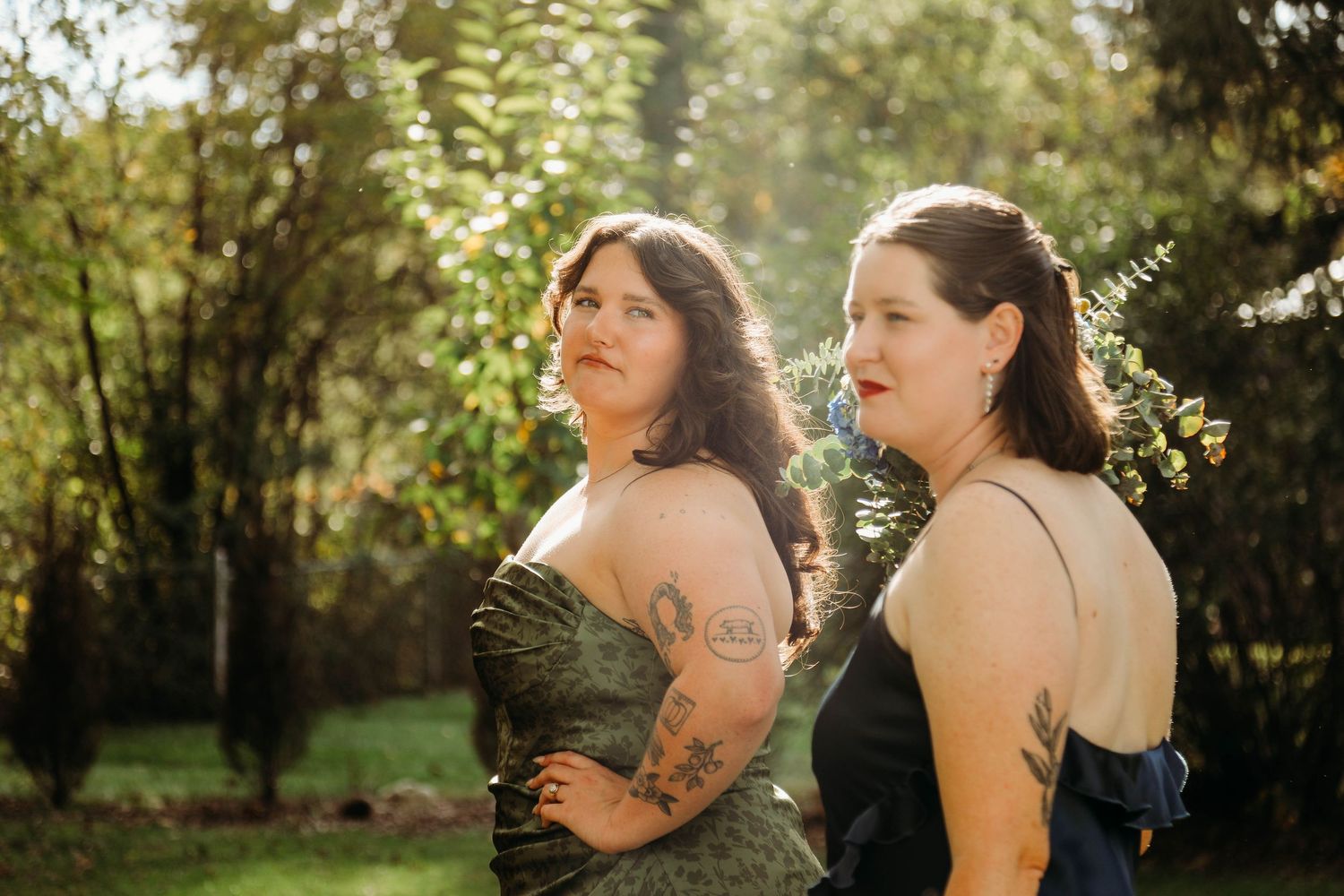 Bridesmaids in burgundy dresses standing together during an outdoor fall wedding.