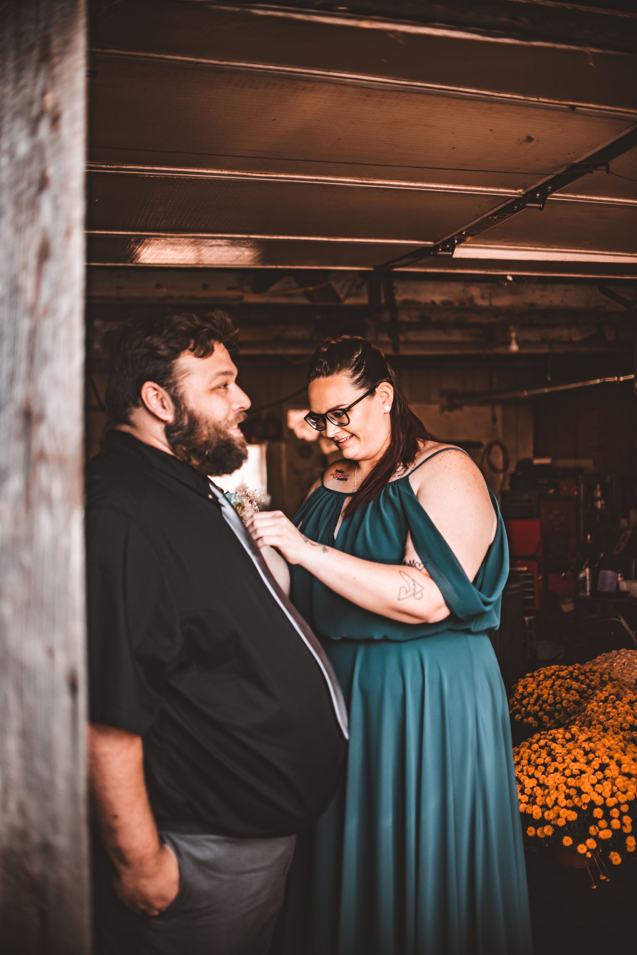 Intimate wedding moment captured in rustic barn setting with warm lighting.
