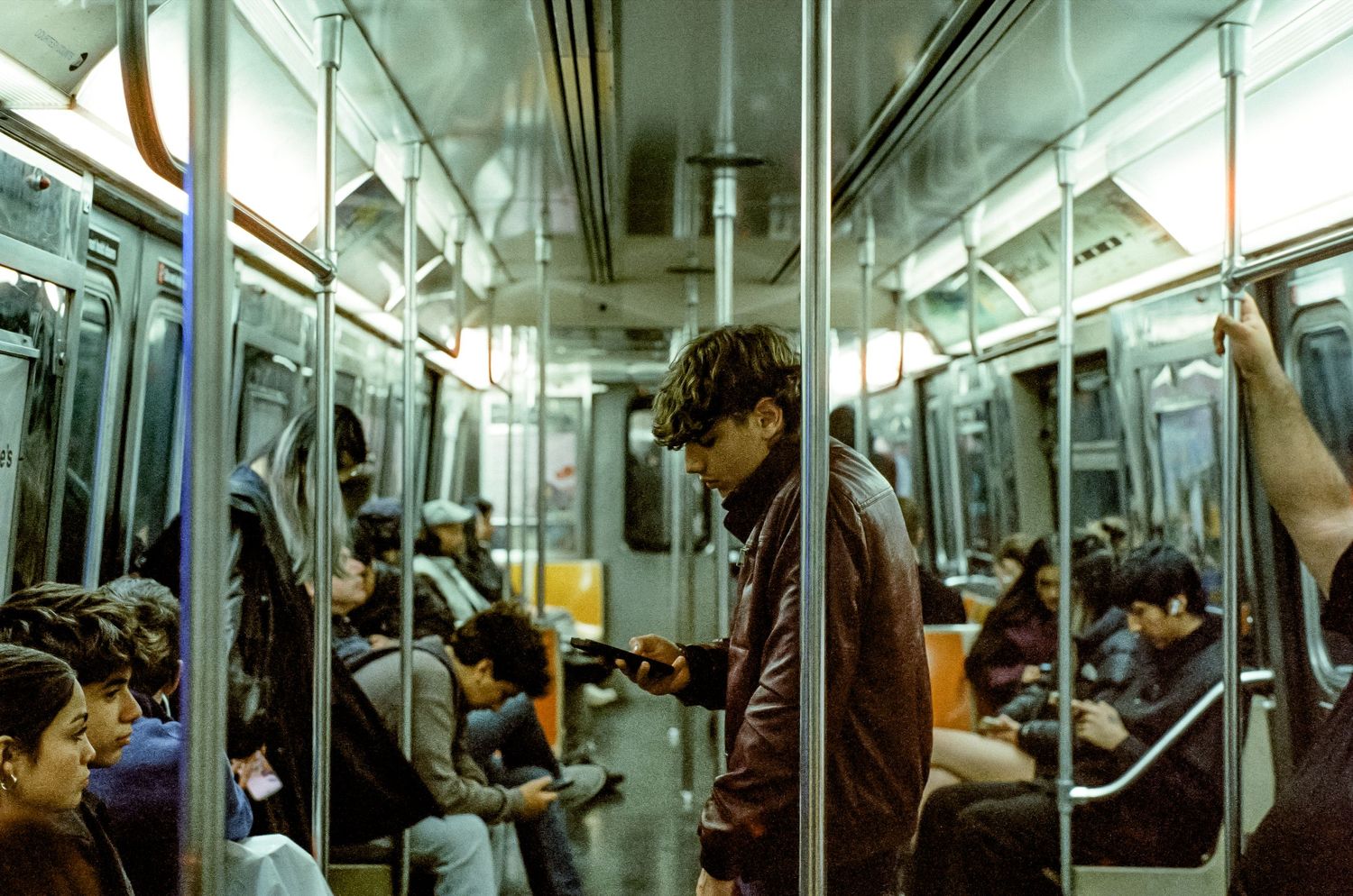 Interior of a subway car with passengers during their commute.