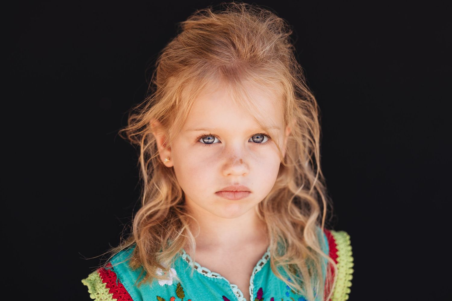 Artistic portrait with dramatic lighting highlighting natural features against dark background.