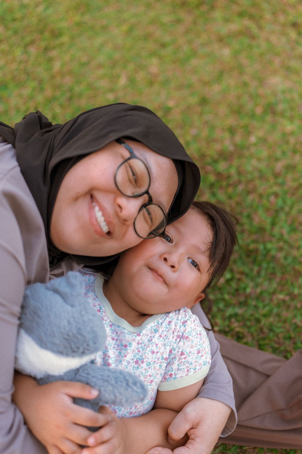 A heartwarming moment of closeness on the grass showing genuine warmth and joy in natural lighting.